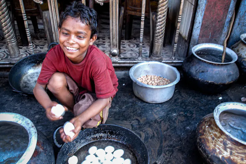 Boy peeling eggshell