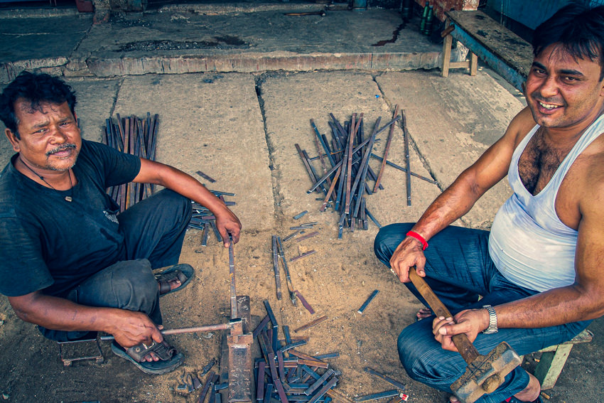 Men cutting iron poles