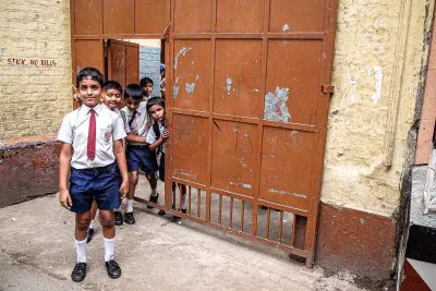 School boy with tie standing in front of gate