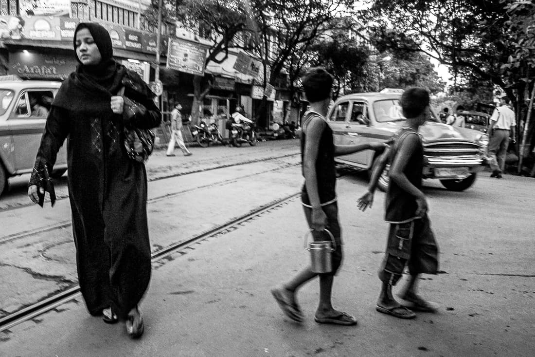 Muslim woman and boys crossing street