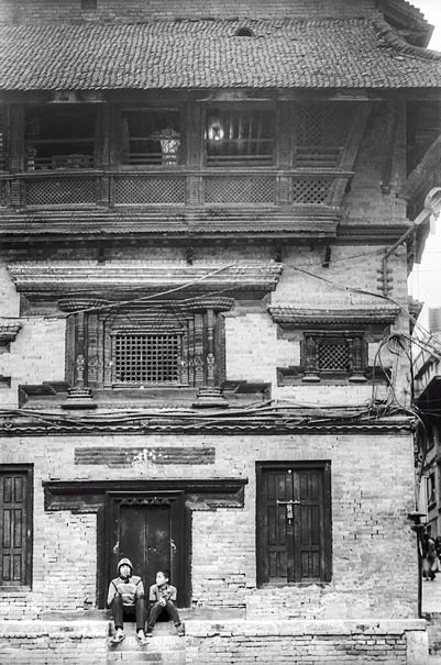 Man and boy in front of traditional house