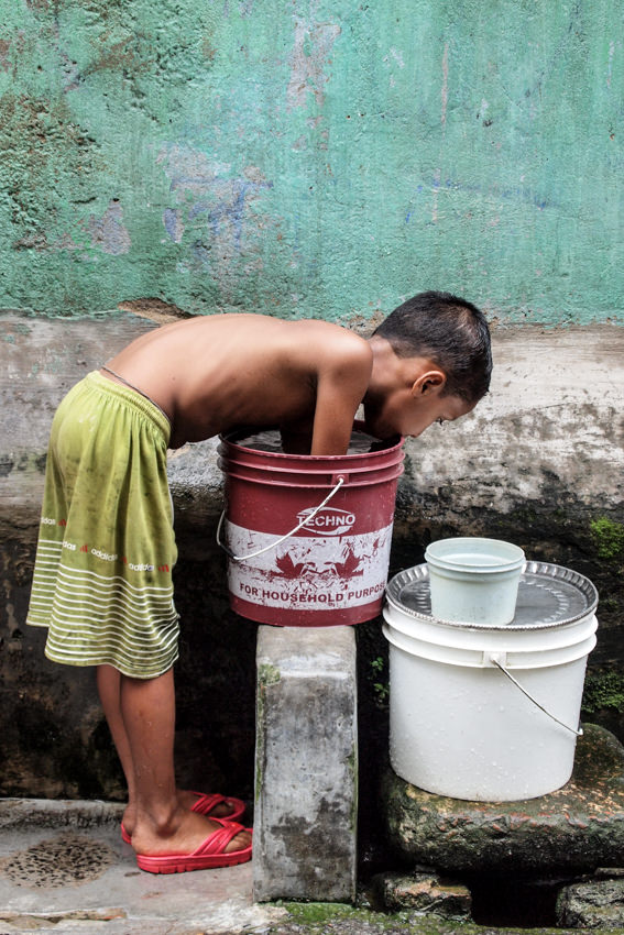 Boy putting hands into bucket