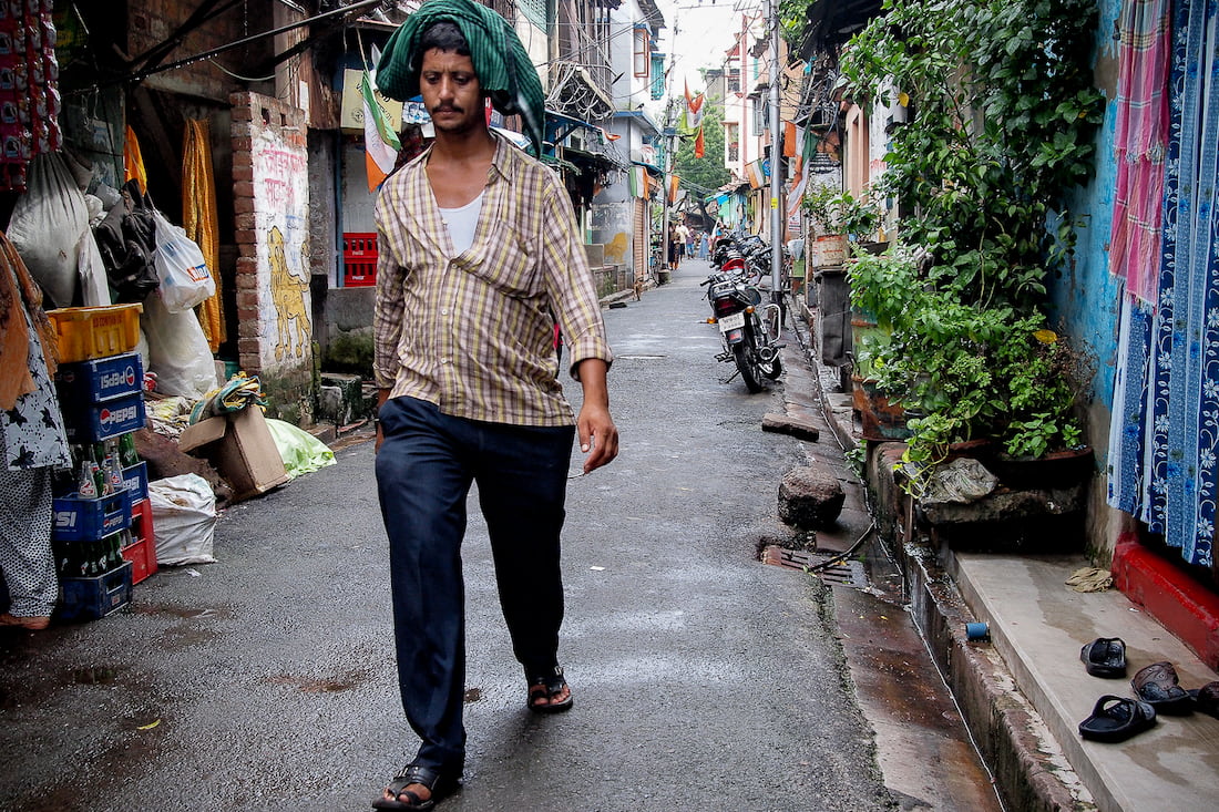 Man walking silently down an alley in a light rain