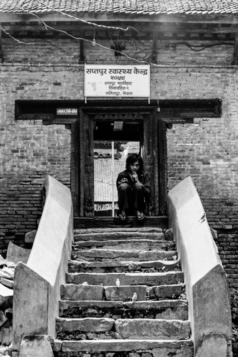 戸口にしゃがむ若者