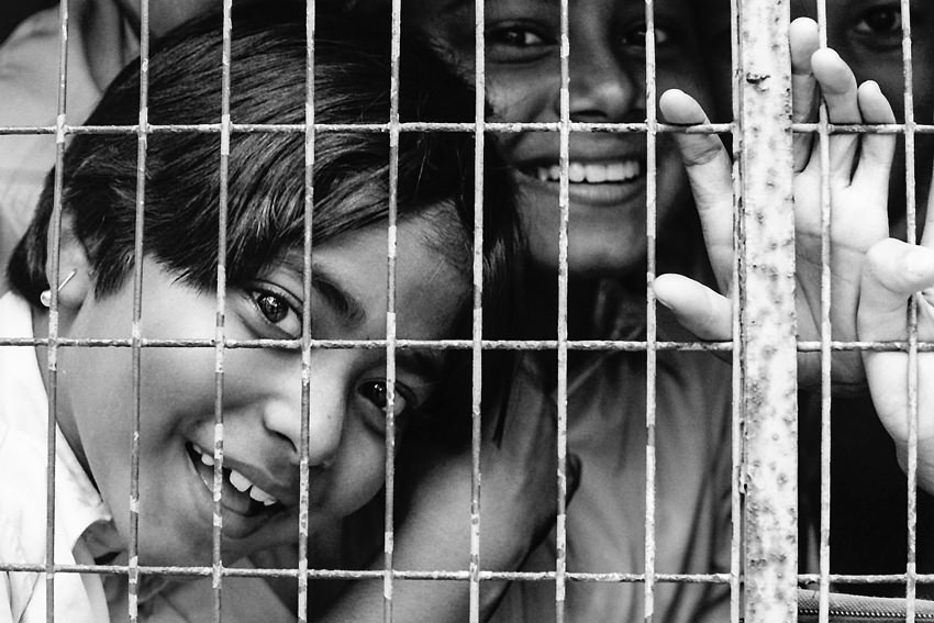 School kids on the other side of bars