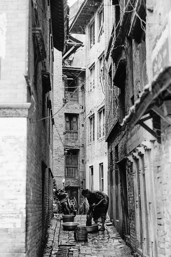 Woman washing in the dim lane