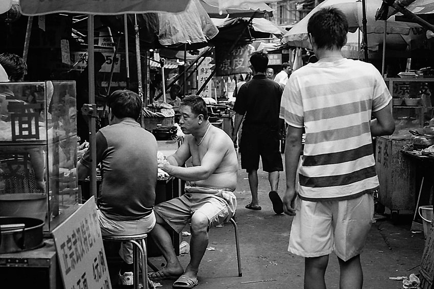 Topless man in food stall