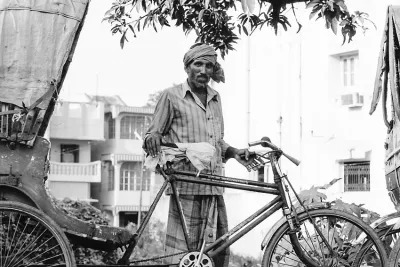 Man standing by cycle rickshaw