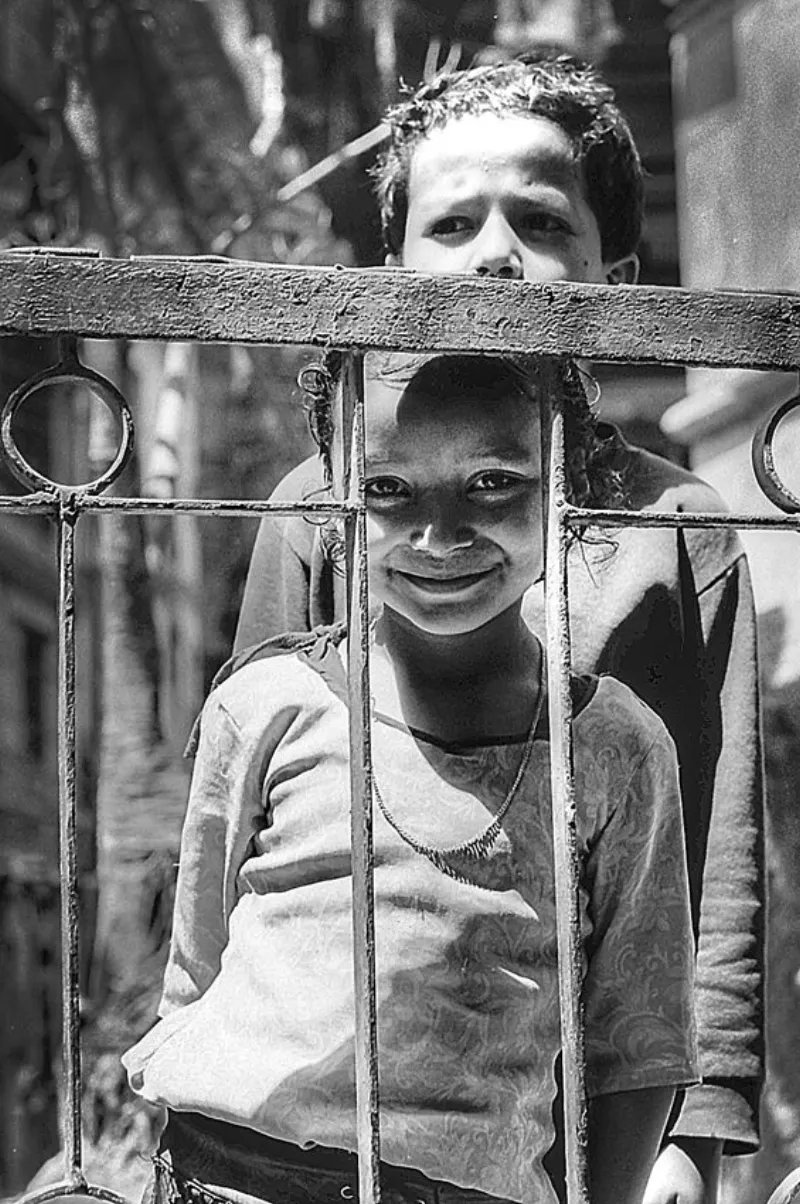 フェンスの向こうに立つ女の子と男の子