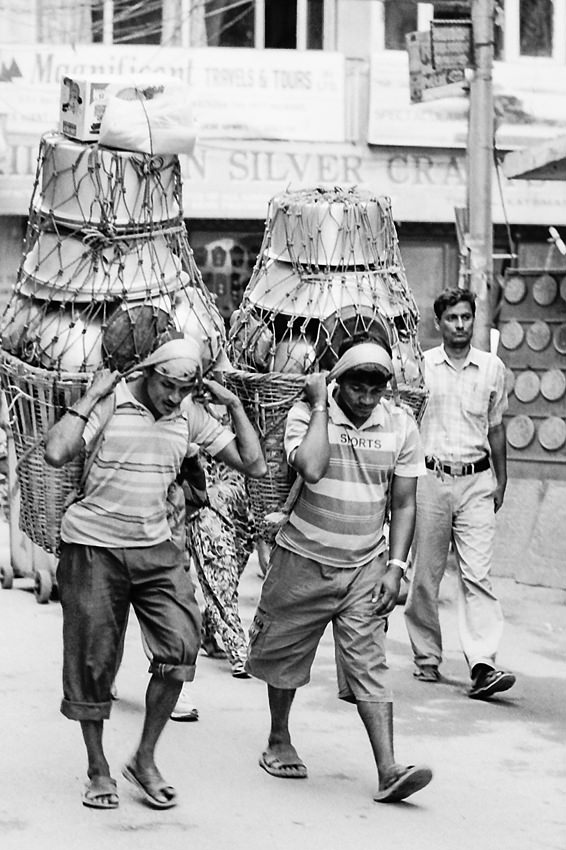 ナムロとドコで金属製の容器を運ぶ男たち
