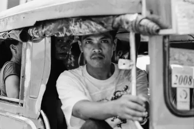 Man holding the handrail on Jeepney