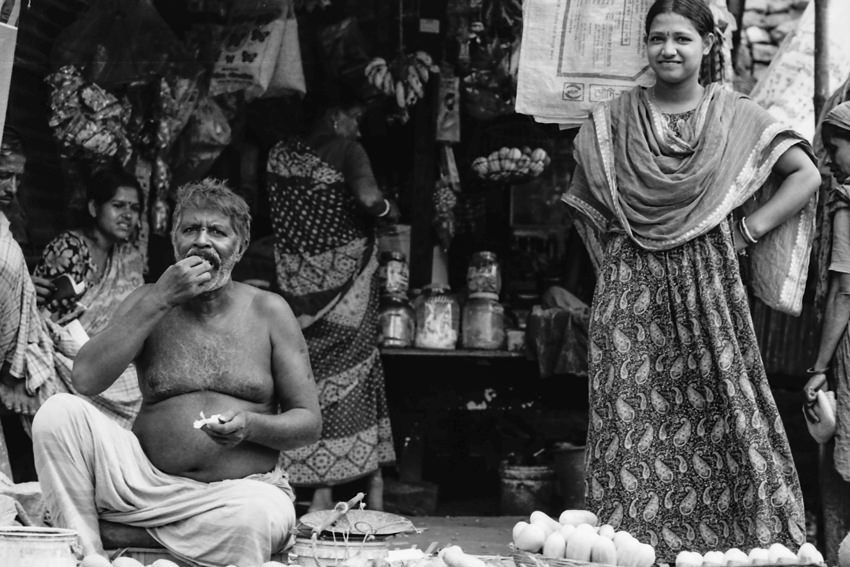 Eating man and standing woman by roadside