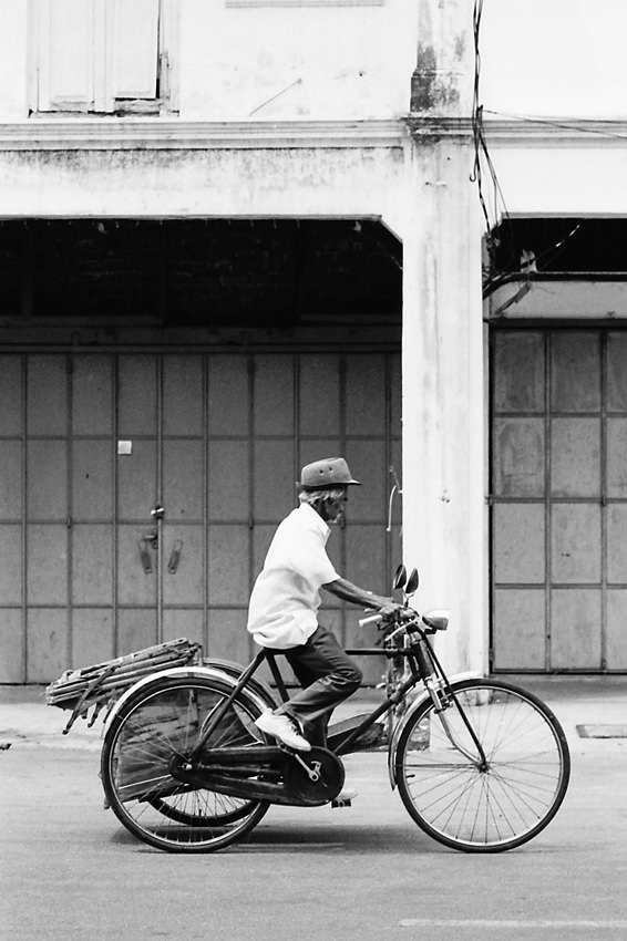 Old man pedaling trishaw