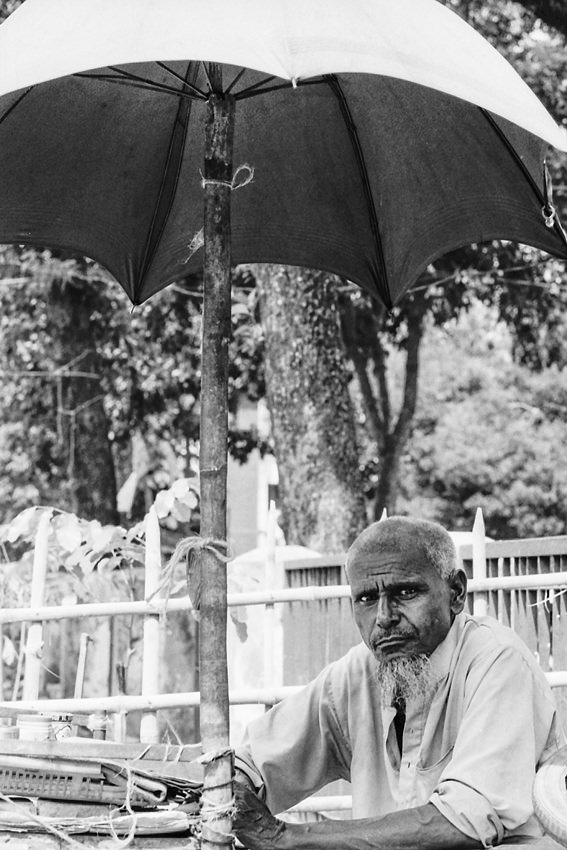 Man killing time under sunshade