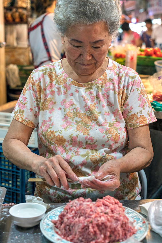 Woman wrapping minced flesh