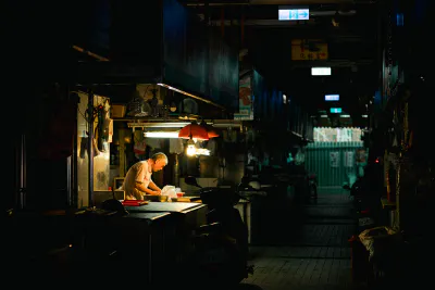 man working in dim Shuixian Temple Market