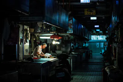 man working in dim Shuixian Temple Market