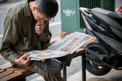 新聞を読む老眼の男