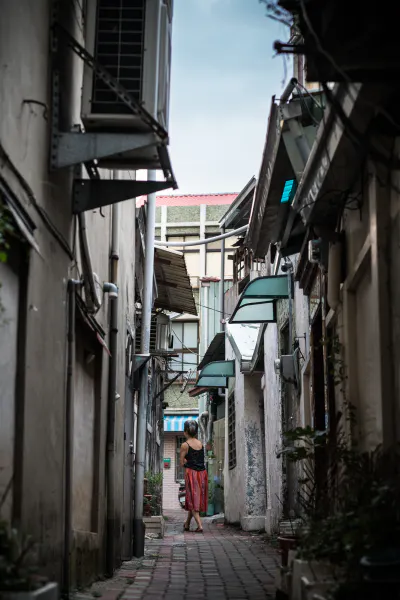 路地をフラフラと歩く女性