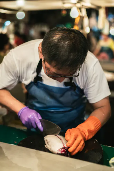 Fishmonger cutting a fish