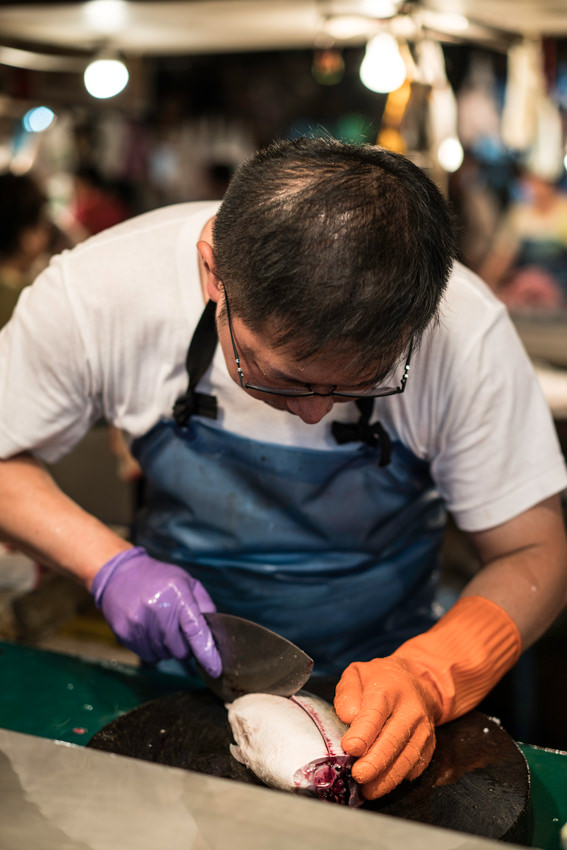 Fishmonger cutting a fish