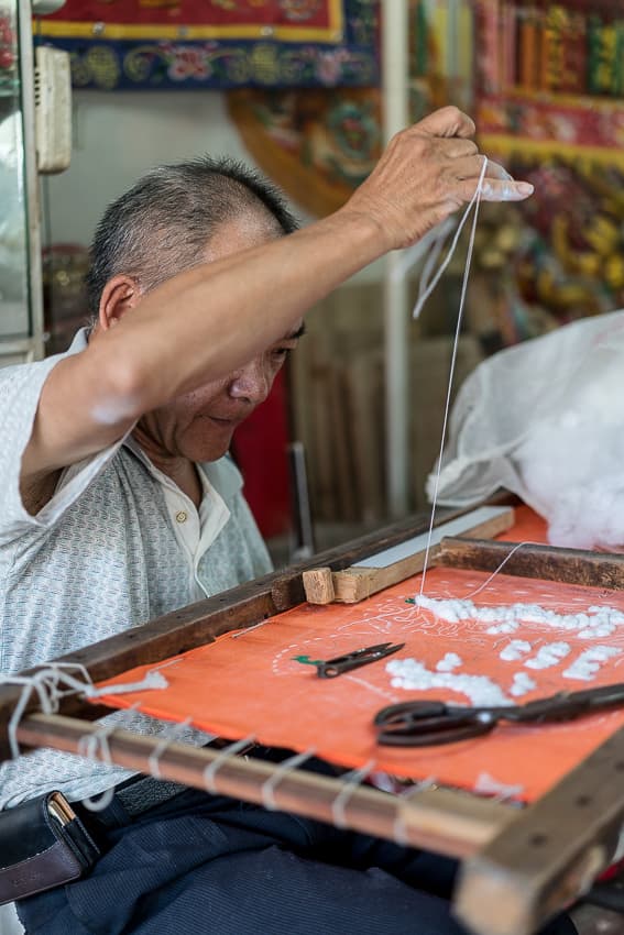man stitching banner