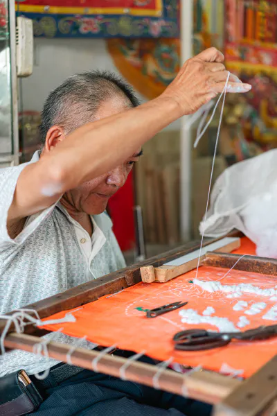 Man stitching a banner