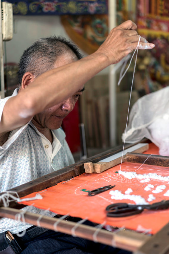 man stitching banner