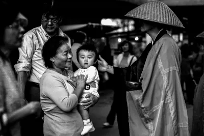 Monk stroking baby's head