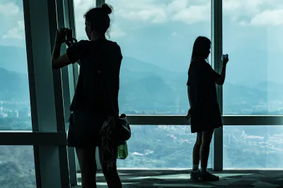 Two silhouetted women taking photos