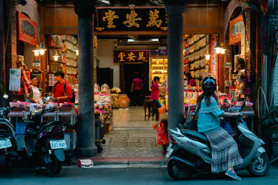 Young woman on motorbike stopping in storefront