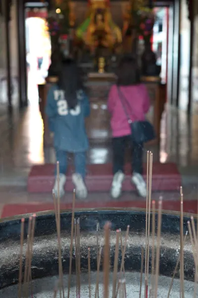 Two women at other side of incense burner