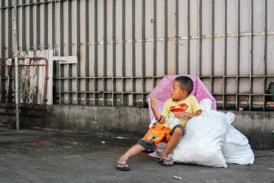 袋の上に座る男の子