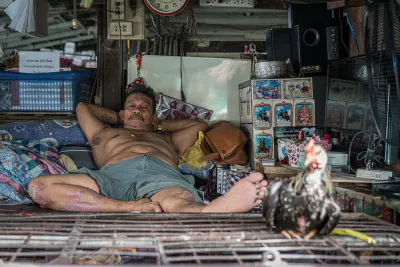Man laying on his back at the Khlong Toei Market
