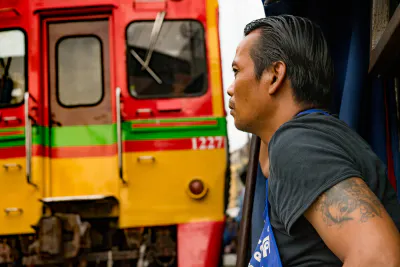Train and man in Mae Klong market