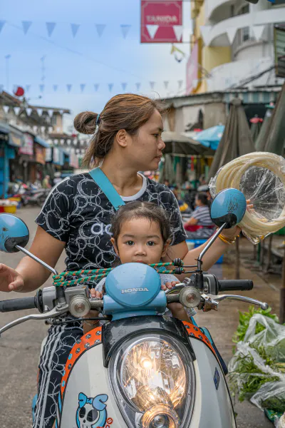 Little girl riding motorbike with mother