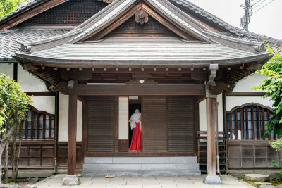 Shinto priestess getting into a building