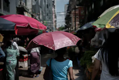 Woman walking street market with umbrella