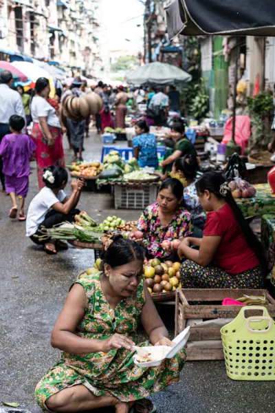 Women sitting on side of street market