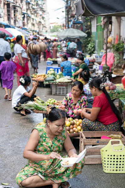 Women sitting on side of street market