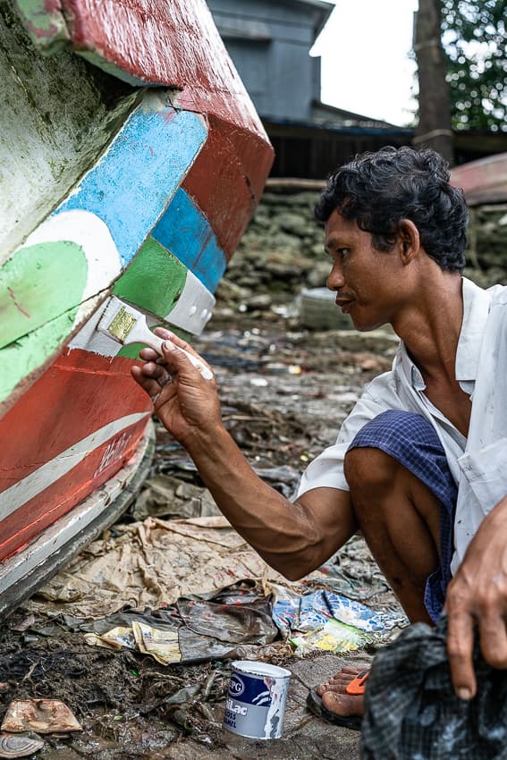 Man recoloring fishing boat