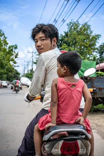 Young father riding motorbike with little daughter