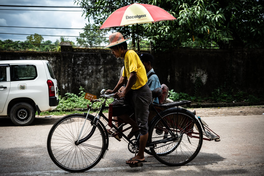 Pedicab with umbrella passing by