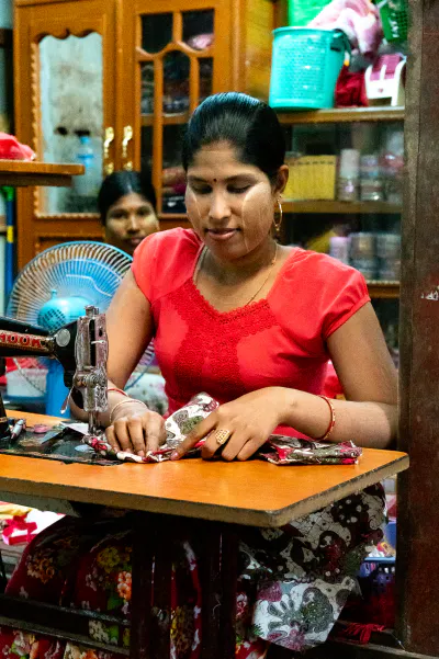 Woman sewing in dim shop