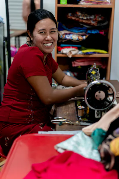 Woman smiled beside sewing machine