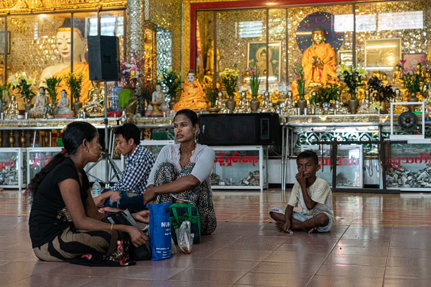 Local people relaxing in front of Buddha statues