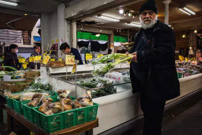 Man standing in front of vegetables in supermarket