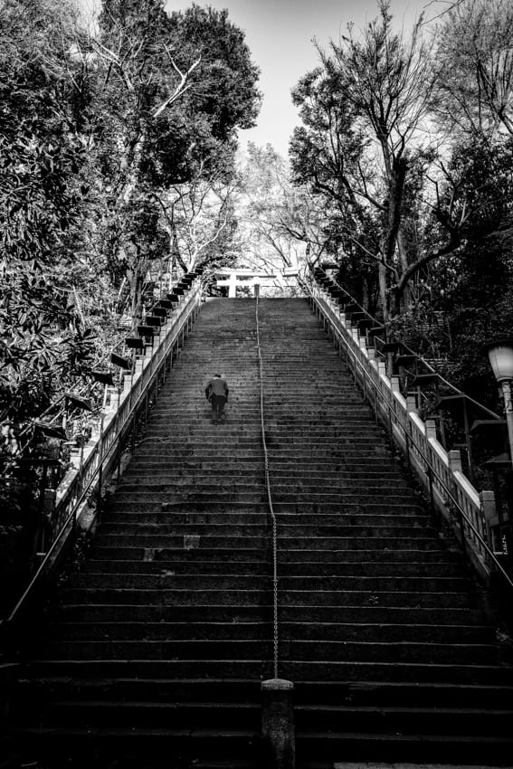 Businessman on steep stairway to Atago Jinja