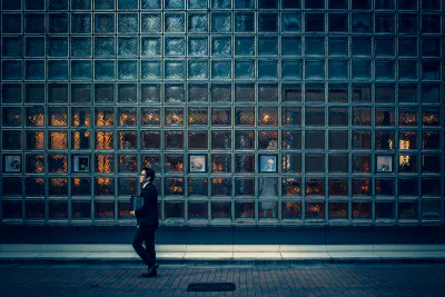 Businessman walking in front of glassed wall