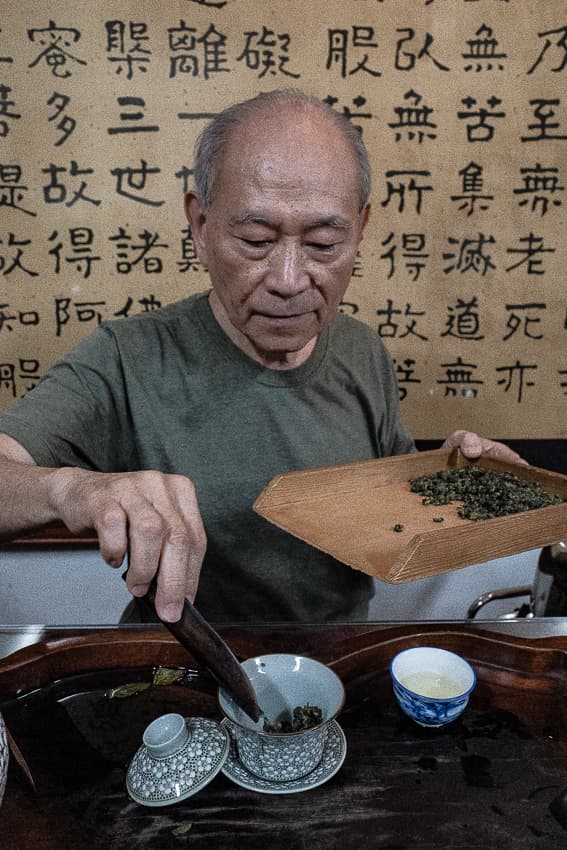 Man setting tea leaves in cup